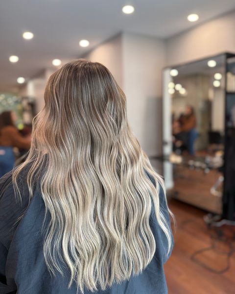 Balayage beige sur cheveux longs ondulés